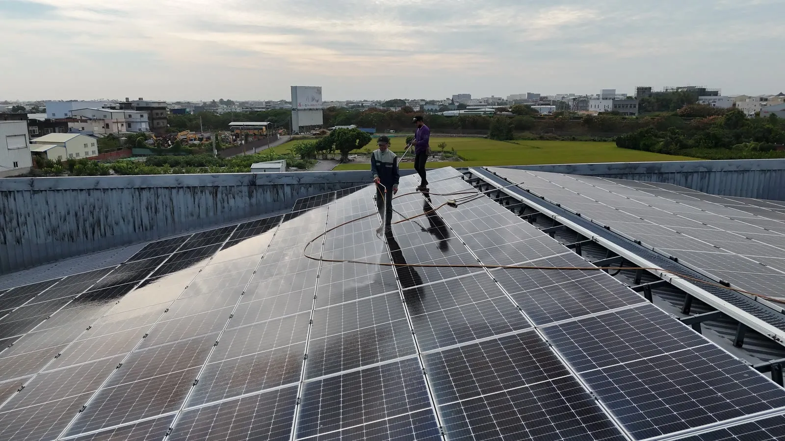 鐵正綱一廠屋頂型太陽能支架工程|屋面清洗作業,遠處是彰化的平原與市區